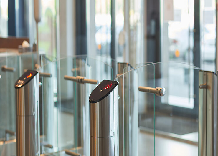 Background of glass doors with automated gate at entrance to office building or college, copy space