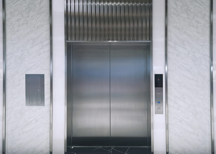 Modern elevator or lift doors made of metal closed in building w Modern elevator or lift doors made of metal closed in building with lighting